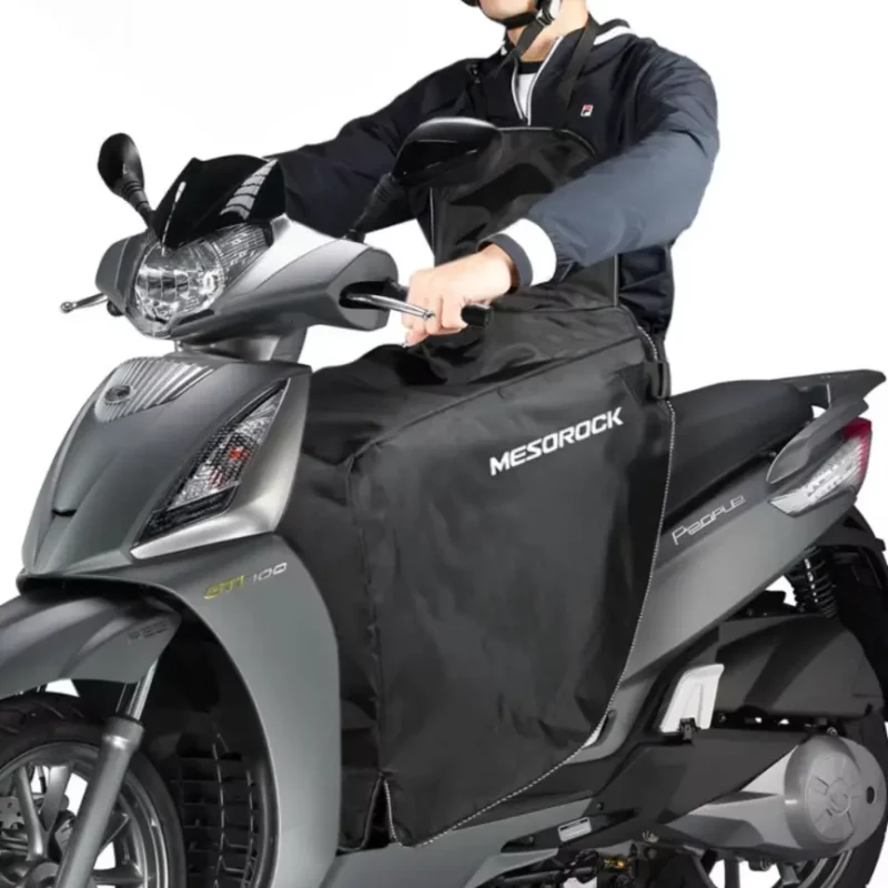 Tablier scooter coupe-vent en utilisation réelle. Protège efficacement du froid, du vent et de la pluie pour des trajets confortables.
