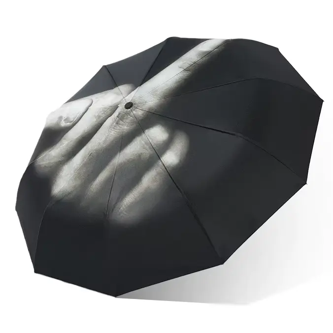 Parapluie noir motif doigt d’honneur vu de biais. Tissu mat, contraste fort, pour affirmer ton style en toutes saisons.