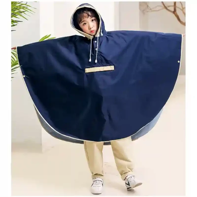 Poncho bleu marine pour enfant, forme cape large et capuche protectrice. Imperméable, confortable et idéal pour les sorties sous la pluie.
