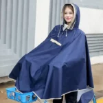 Poncho vélo bleu marine pour adulte, parfait par temps de pluie. Grande couverture avant, capuche réglable et tissu imperméable pour trajets au sec.
