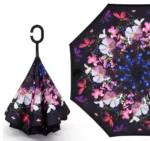 Parapluie inversé noir avec poignée en C. Motif fleurs et papillons élégant sous la toile. Protection pluie moderne, esthétique et fonctionnelle.