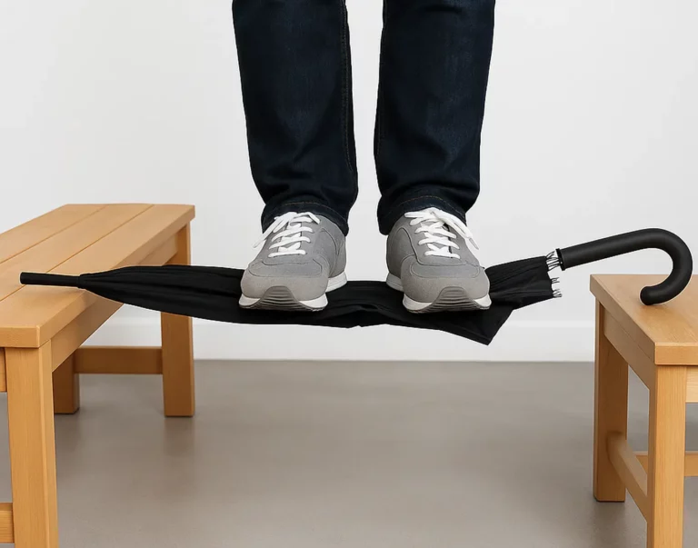 Un homme debout sur un parapluie fermé : test de solidité extrême. Parapluie noir, structure renforcée, supporte le poids d’un adulte sans casser.