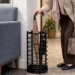 Porte-parapluie noir en métal pour entrée moderne, grande stabilité, rangement propre des parapluies mouillés, style sobre et chic.
