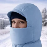 Capuche bleue coupe-vent avec cache-visage intégré. Garde le visage au chaud contre le vent, neige et glace. Parfaite ski, rando et sortie hivernale.