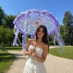 Ombrelle mariage violet et blanc avec fleurs et rubans, style japonais élégant idéal pour cérémonie romantique et photos lumineuses.