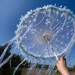 Ombrelle mariage bleu pastel avec fleurs et rubans flottants, style féerique parfait pour cérémonie bohème chic et ambiance douce.